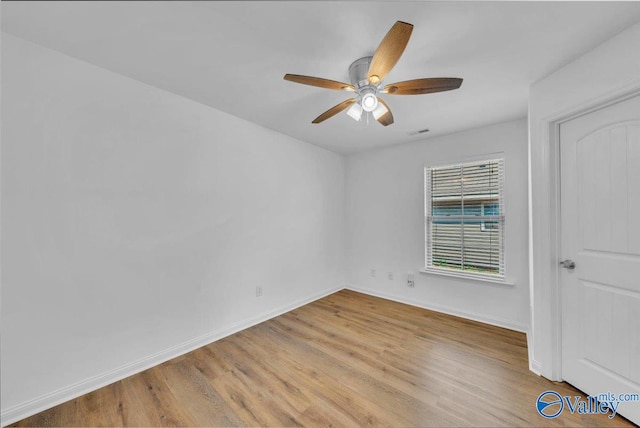 unfurnished room with ceiling fan, visible vents, baseboards, and light wood-style flooring