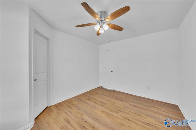 empty room with baseboards, a ceiling fan, and light wood-style floors