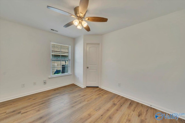 unfurnished room featuring ceiling fan, visible vents, baseboards, and wood finished floors