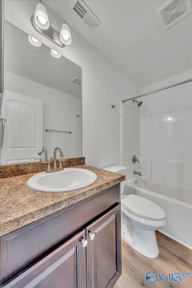 bathroom featuring vanity, wood finished floors, visible vents, and bathtub / shower combination