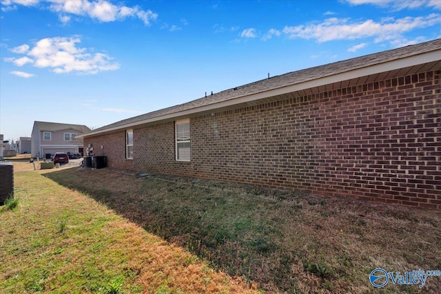 view of property exterior with a lawn, brick siding, and central AC