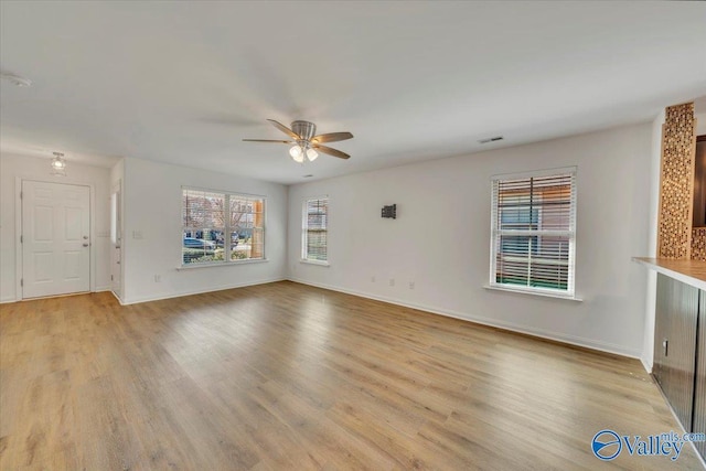 unfurnished living room with baseboards, visible vents, light wood finished floors, and ceiling fan