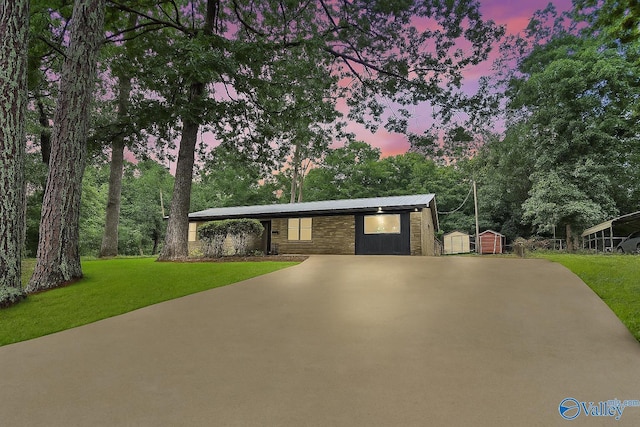 216 Mcdonald Ln, Guntersville, AL 35976 - mid-century inspired home featuring a storage shed, a front lawn, a metal roof, and concrete driveway
