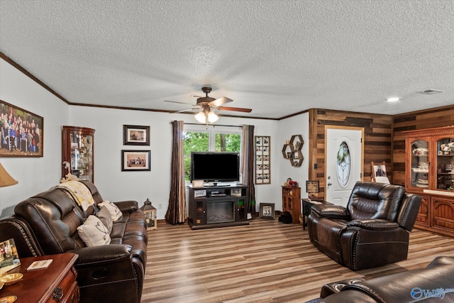 216 Mcdonald Ln, Guntersville, AL 35976 - living area with light wood-style floors, crown molding, a ceiling fan, wooden walls, and a textured ceiling