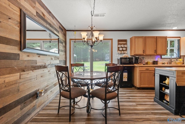 216 Mcdonald Ln, Guntersville, AL 35976 - dining room with wood walls, a textured ceiling, dark wood finished floors, plenty of natural light, and a chandelier