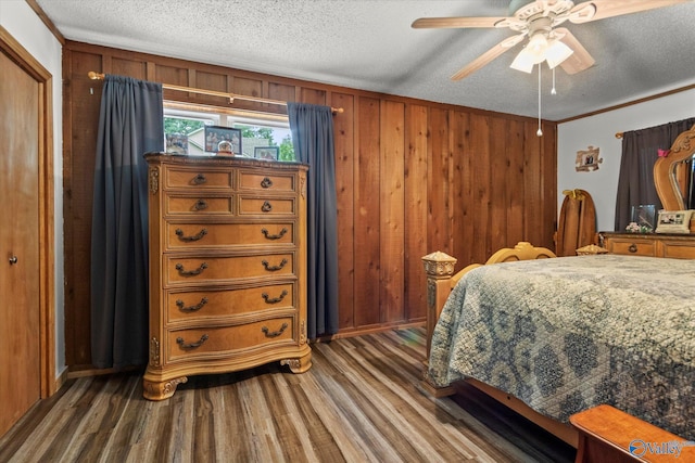 216 Mcdonald Ln, Guntersville, AL 35976 - bedroom featuring wood finished floors, a textured ceiling, wood walls, and a ceiling fan
