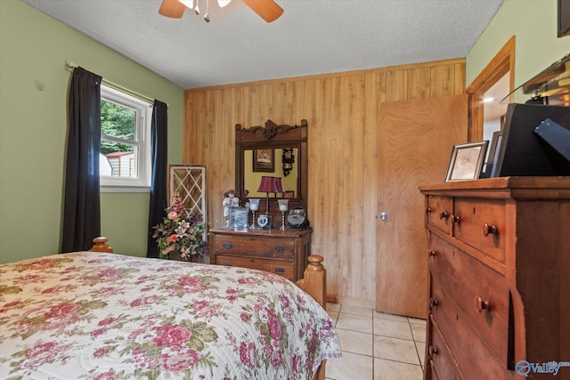 216 Mcdonald Ln, Guntersville, AL 35976 - bedroom featuring wooden walls, a textured ceiling, ceiling fan, and light tile patterned floors
