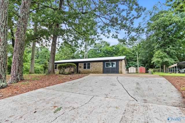 216 Mcdonald Ln, Guntersville, AL 35976 - ranch-style house with a storage unit, driveway, view of scattered trees, and a carport