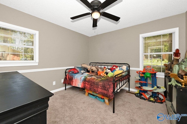 bedroom featuring a textured ceiling, carpet flooring, and ceiling fan