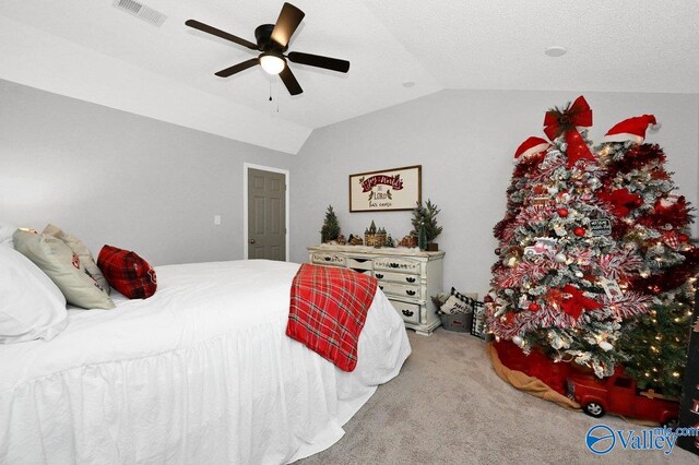 bedroom featuring a textured ceiling, lofted ceiling, visible vents, ceiling fan, and carpet