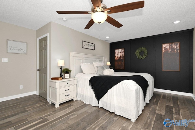 bedroom with a ceiling fan, dark wood-type flooring, baseboards, and a textured ceiling