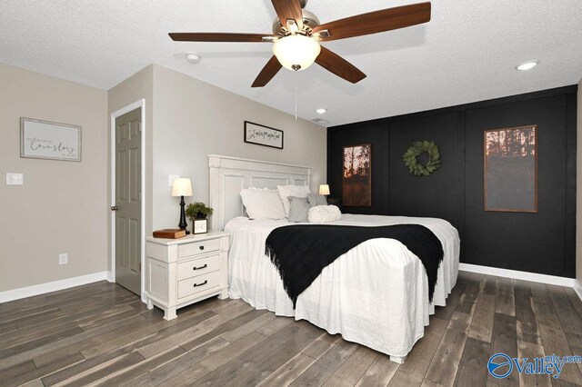 bedroom with ceiling fan, hardwood / wood-style flooring, and a textured ceiling