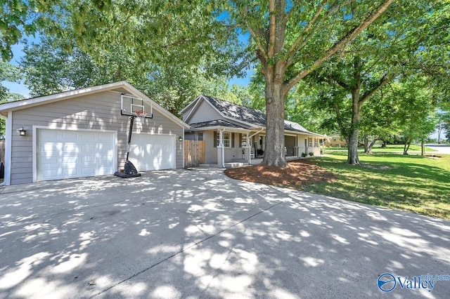 view of front facade featuring driveway, a front yard, an outdoor structure, and a porch