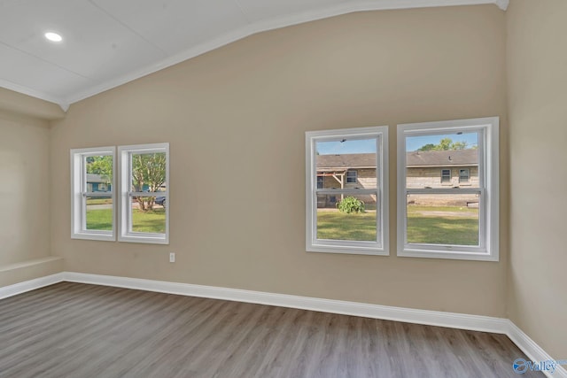 spare room with crown molding, baseboards, lofted ceiling, and wood finished floors