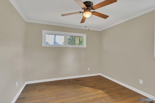 spare room featuring crown molding, baseboards, and wood finished floors