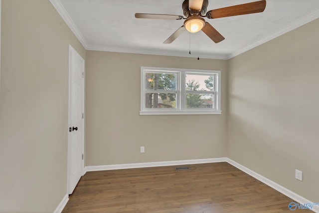 spare room with ceiling fan, baseboards, wood finished floors, visible vents, and ornamental molding