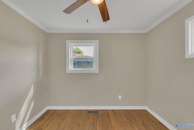 unfurnished room with visible vents, baseboards, crown molding, and wood finished floors