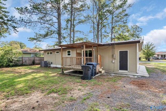rear view of house featuring central air condition unit, fence, a yard, and a deck