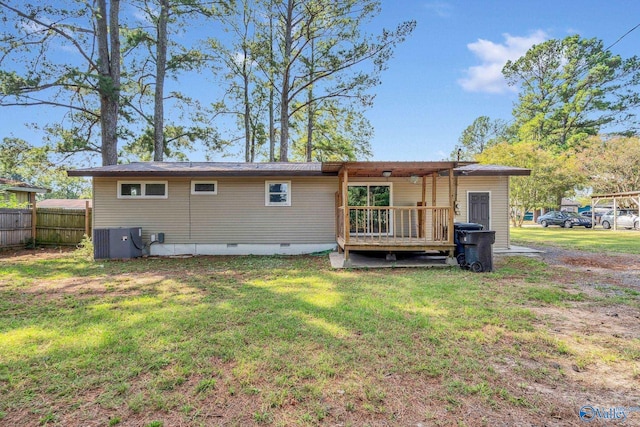 rear view of property with a wooden deck, a lawn, and central air condition unit