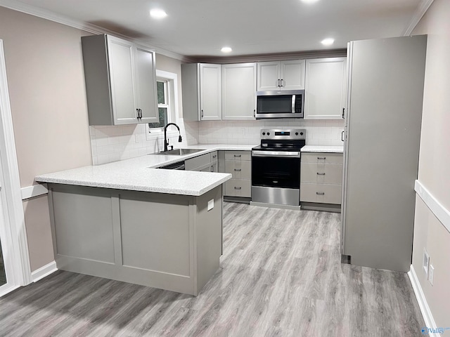 kitchen with light hardwood / wood-style floors, stainless steel appliances, crown molding, and sink