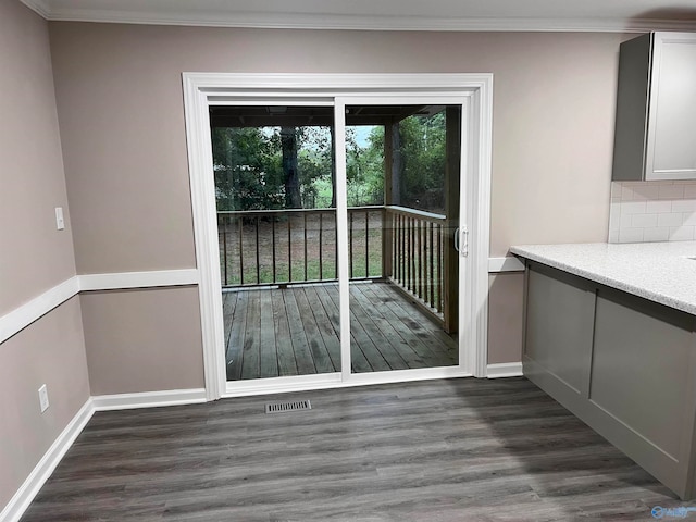 doorway with ornamental molding and dark wood-type flooring