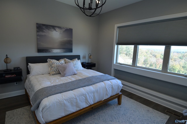 bedroom featuring a chandelier and wood-type flooring