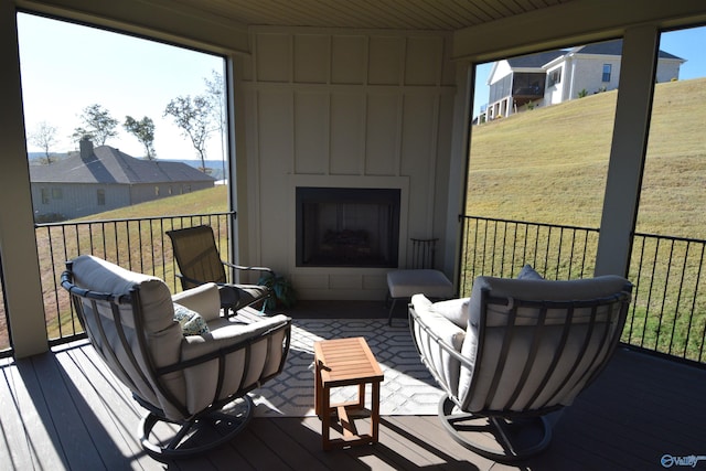 sunroom / solarium with a wealth of natural light, a large fireplace, and wooden ceiling