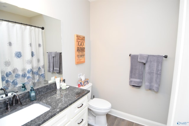 bathroom with vanity, hardwood / wood-style flooring, and toilet