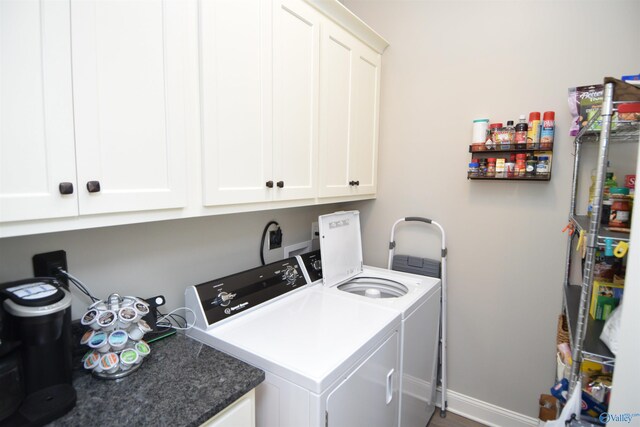 clothes washing area featuring washing machine and dryer and cabinets