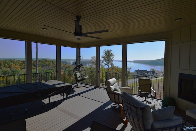 sunroom / solarium with a water view and ceiling fan