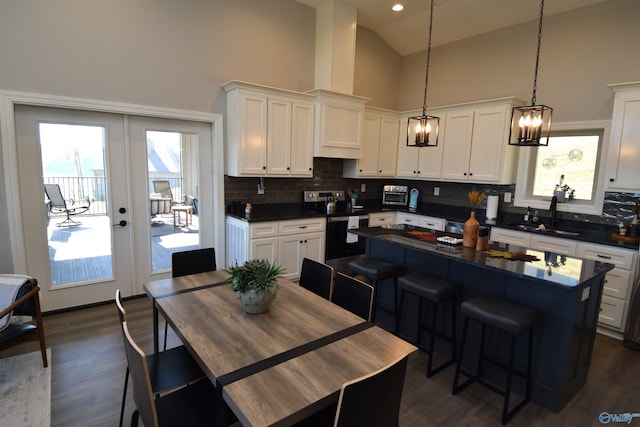 kitchen with french doors, stainless steel electric range oven, high vaulted ceiling, and plenty of natural light