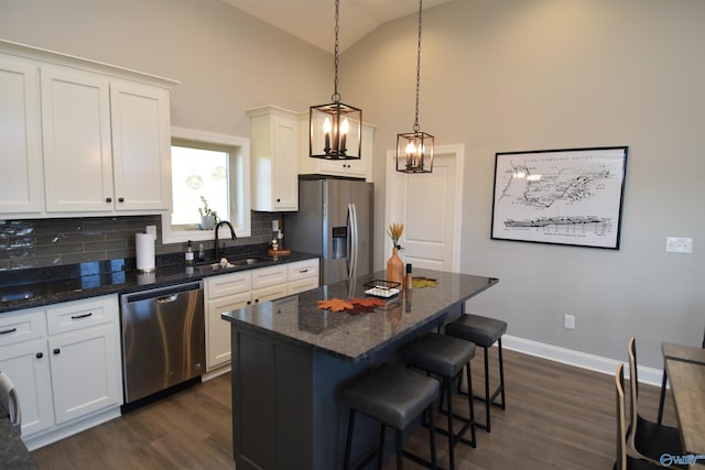 kitchen featuring white cabinets, dark hardwood / wood-style flooring, appliances with stainless steel finishes, a kitchen island, and sink