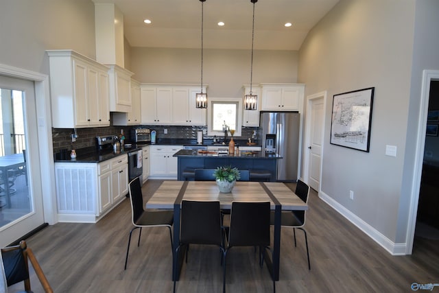 kitchen with a high ceiling, stainless steel appliances, a wealth of natural light, and a kitchen island