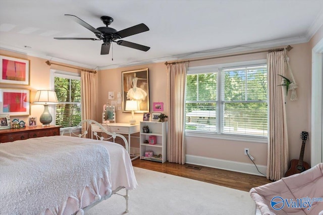 bedroom featuring crown molding, dark wood-type flooring, and ceiling fan