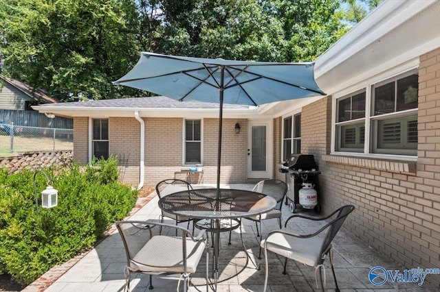 view of patio / terrace with grilling area, outdoor dining space, and fence