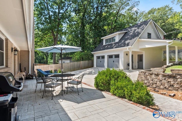 view of patio featuring area for grilling, fence, and an attached garage