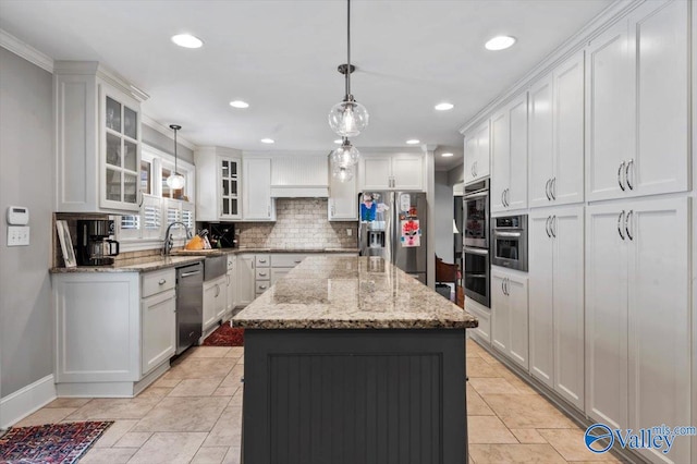 kitchen featuring a center island, stainless steel appliances, hanging light fixtures, and tasteful backsplash