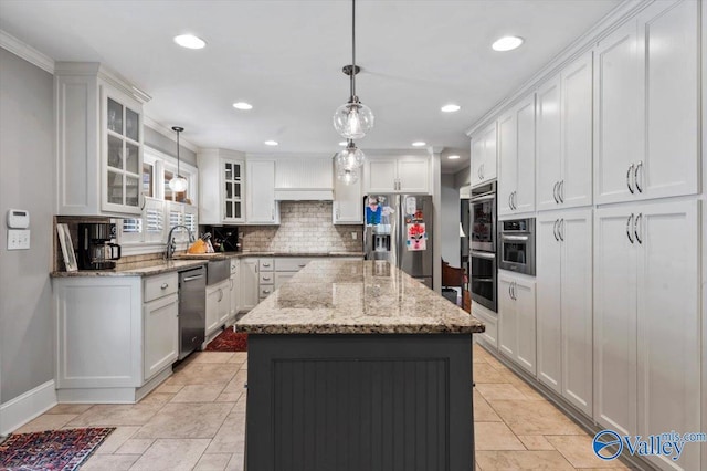 kitchen with white cabinets, tasteful backsplash, a center island, and appliances with stainless steel finishes