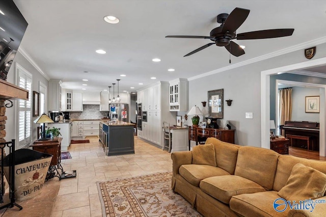 living area with ceiling fan, recessed lighting, ornamental molding, and stone finish flooring