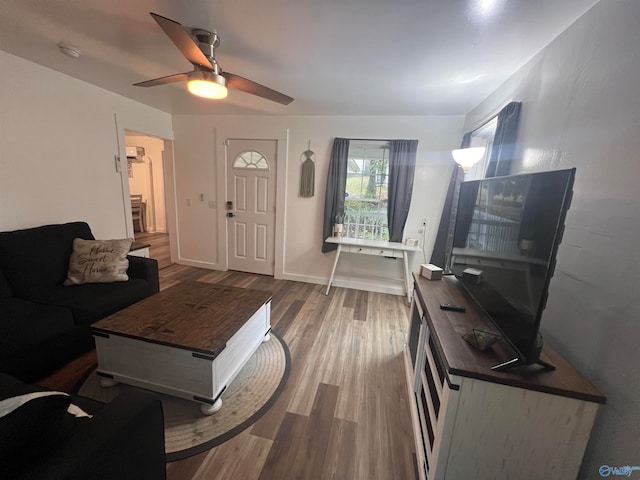 living room featuring wood-type flooring and ceiling fan