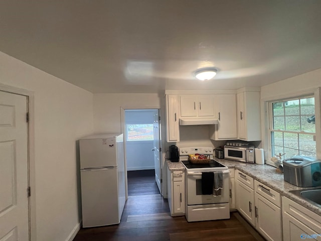 kitchen with white cabinetry, light stone counters, dark wood-type flooring, and white appliances