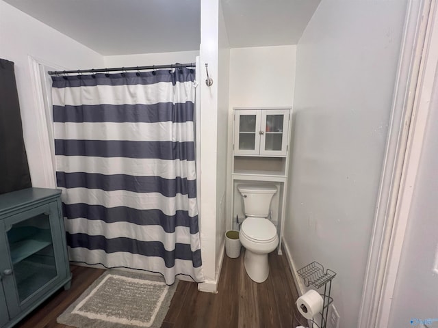 bathroom with toilet, wood-type flooring, and a shower with curtain