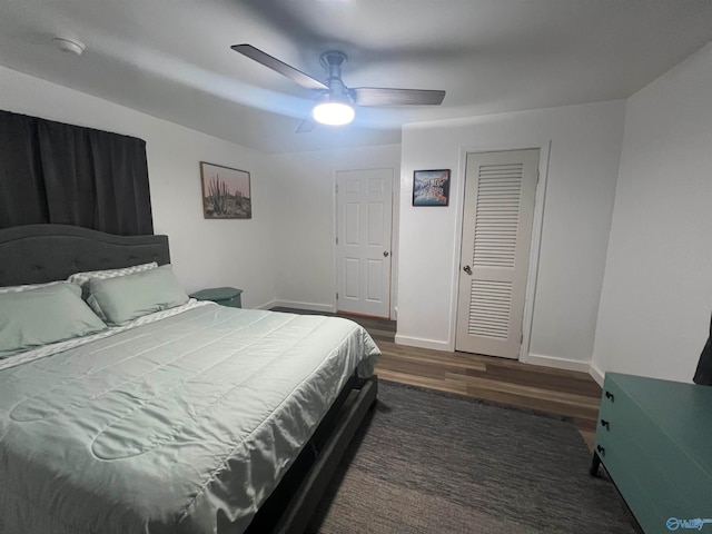 bedroom featuring a closet, dark hardwood / wood-style floors, and ceiling fan