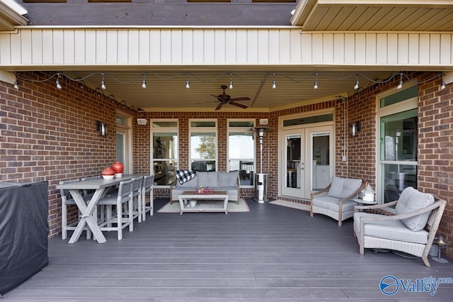 wooden deck with ceiling fan and an outdoor living space