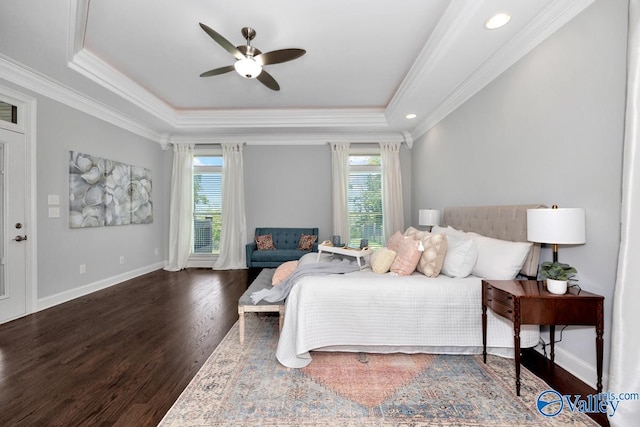 bedroom featuring ornamental molding, multiple windows, a raised ceiling, and dark wood finished floors