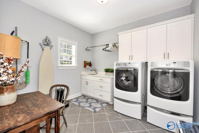 laundry room featuring washer and clothes dryer, cabinet space, a sink, dark tile patterned floors, and baseboards