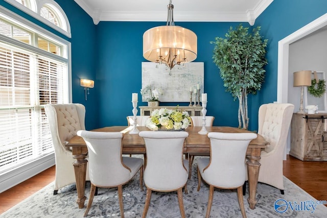 dining area featuring crown molding, wood finished floors, a wealth of natural light, and an inviting chandelier