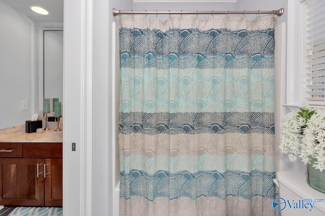 full bathroom featuring toilet, vanity, and a shower with shower curtain