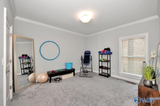 exercise area featuring baseboards, visible vents, ornamental molding, and carpet flooring