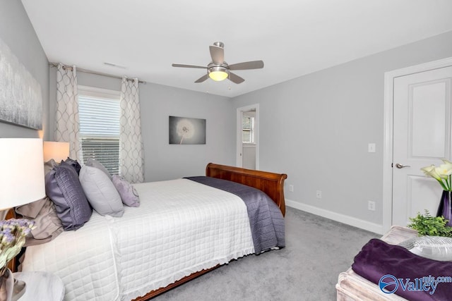 bedroom with light colored carpet, ceiling fan, visible vents, and baseboards